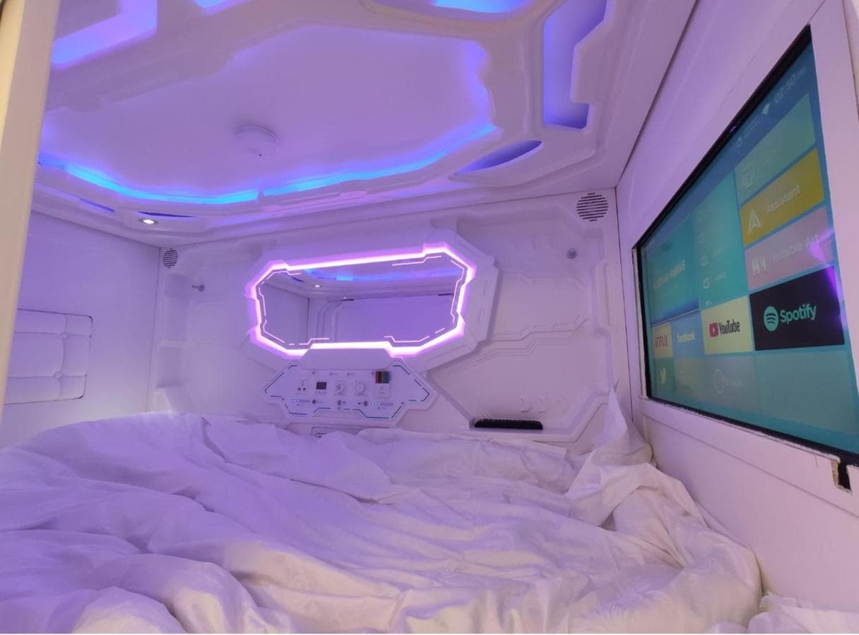 Single capsule interior with smart TV, ambient LED lighting, and premium bedding
